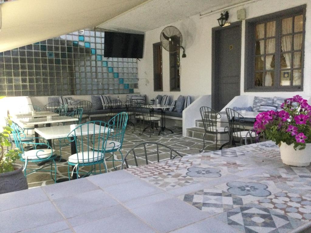 新马尔马拉斯Hotel Sweet Home的庭院配有桌椅和紫色鲜花