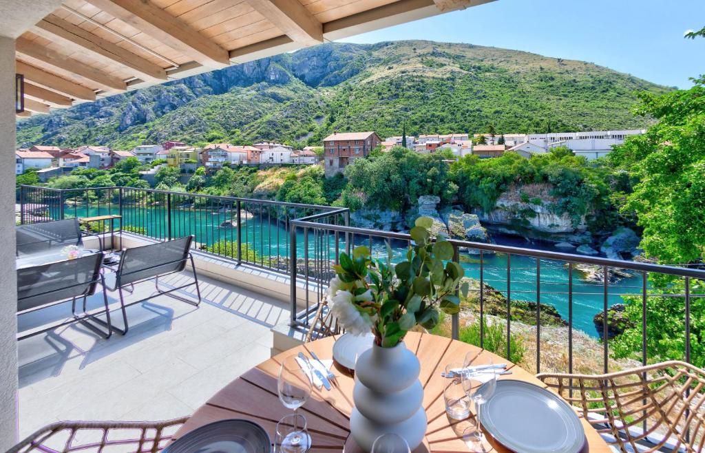 莫斯塔尔Villa Amaleo的阳台配有桌子,享有水景
