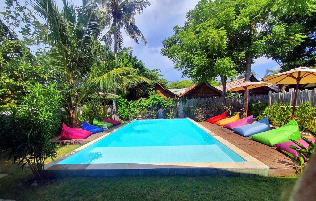 吉利美诺吉利联合彩色酒店的一座带五颜六色椅子的游泳池,位于一座房子旁边