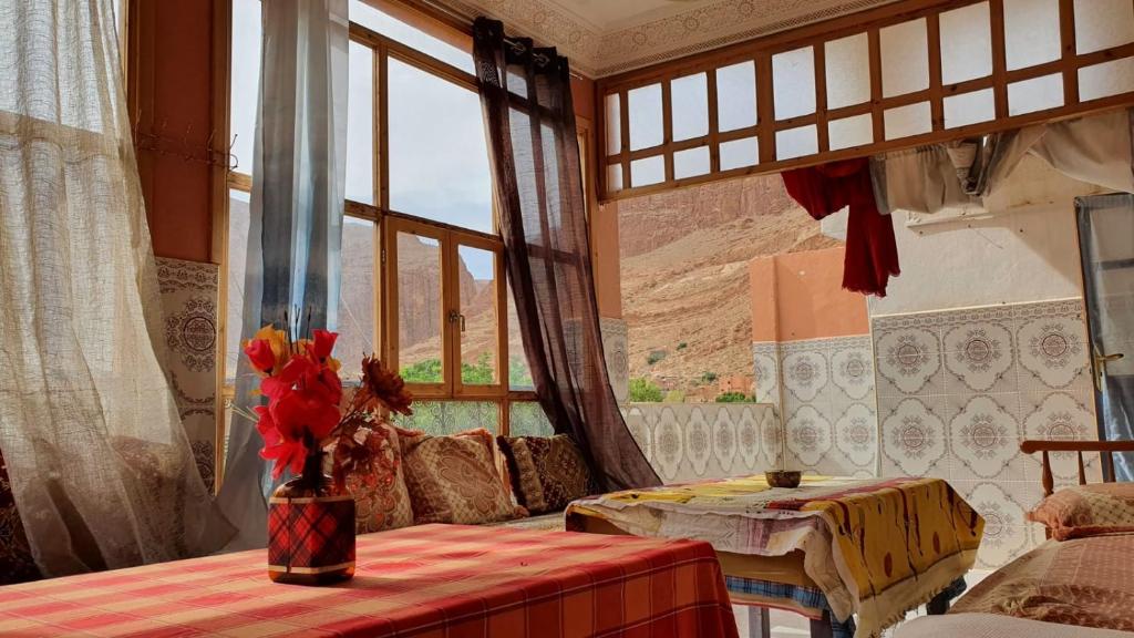 廷吉尔Dar Relax Hostel, Gorges de Todra的客厅配有桌子和窗户