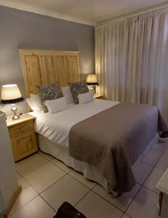 伯利恒Magnolia Over Night Guesthouse的一间卧室配有一张带两盏灯的大型白色床。