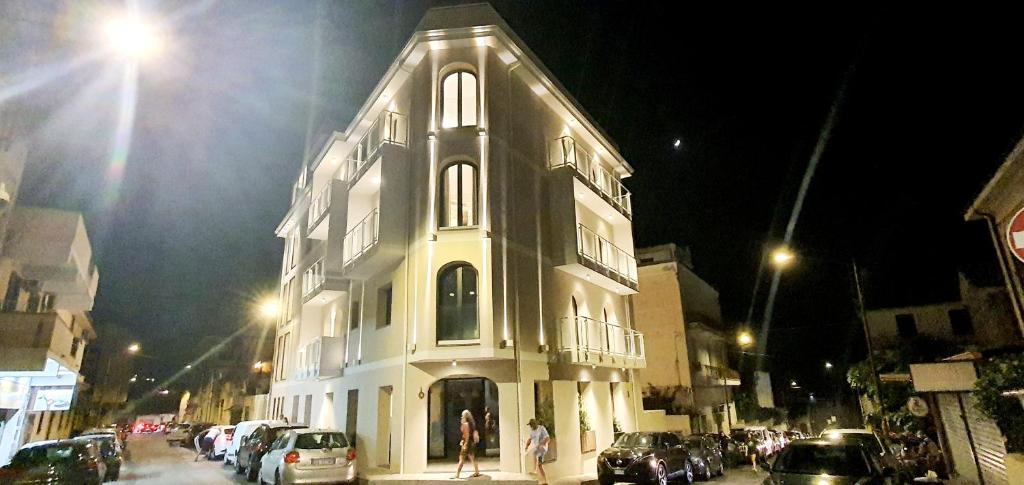 特罗佩阿Solmaris Tropea Rooms & Suites的夜行的街道上一座白色的大建筑