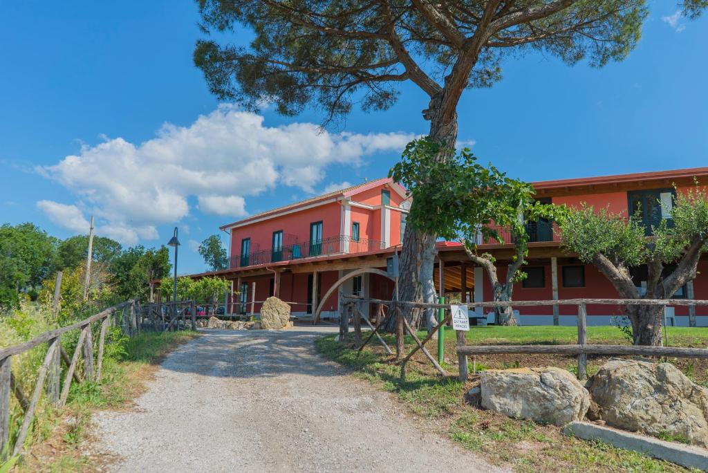 Montecorvino PuglianoTerra di Vento的前面有棵树的红色建筑