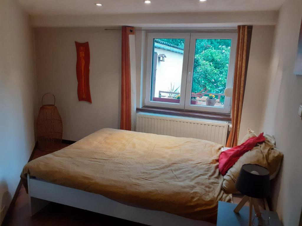 Villers-la-VilleÀ la pause bien méritée =)的一间卧室设有一张床和一个窗口
