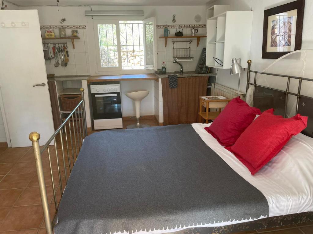 圣埃乌拉利亚retreat studio的一间卧室配有一张带红色枕头的床