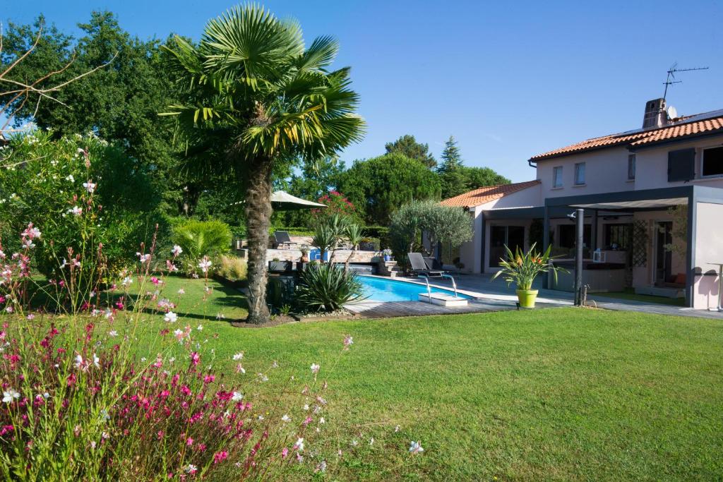 勒皮安·梅多克Wine Hôte Chambre d'hôtes的棕榈树庭院和游泳池