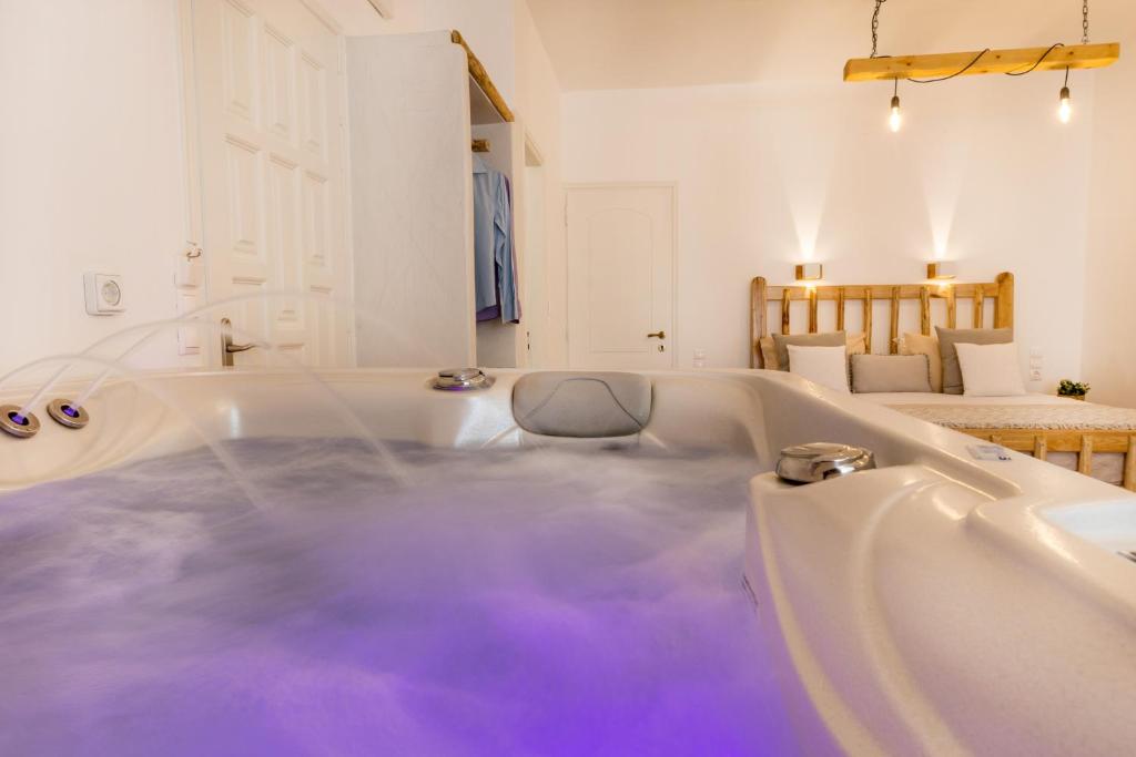 纳克索乔拉Aqua Naxos Apartments & Suites的浴室内装有紫色水的浴缸