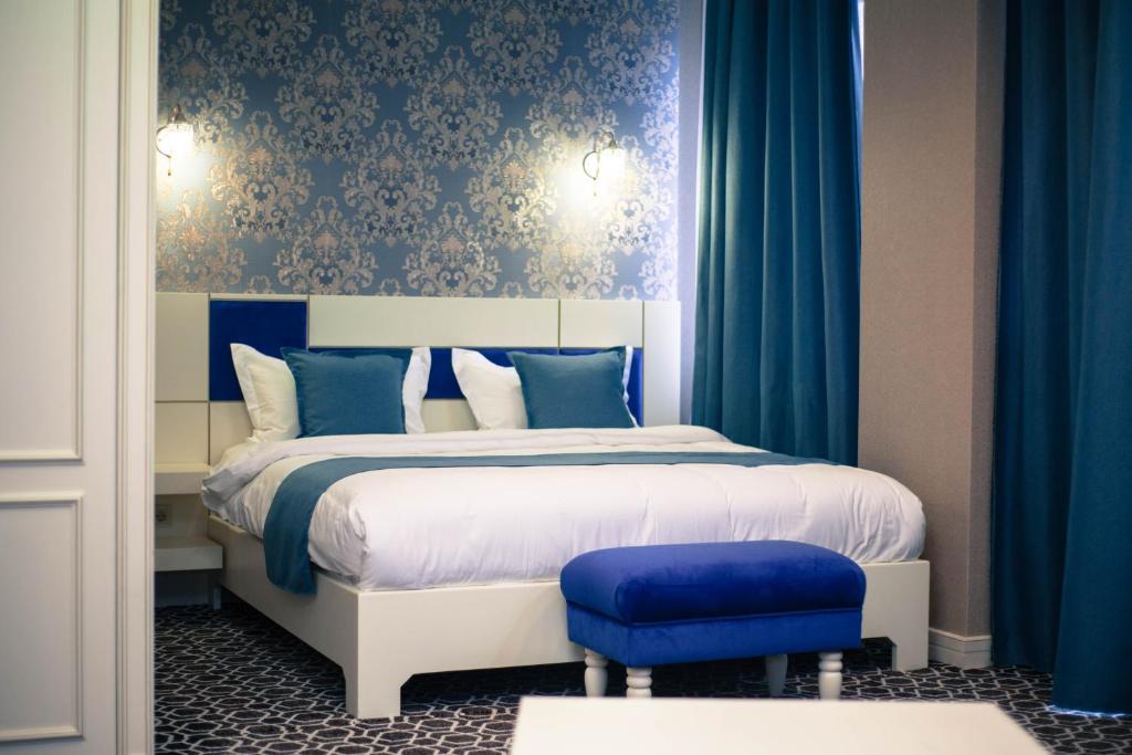 奎兹洛达Park Hotel的一间卧室配有一张蓝色墙壁和蓝色窗帘的床