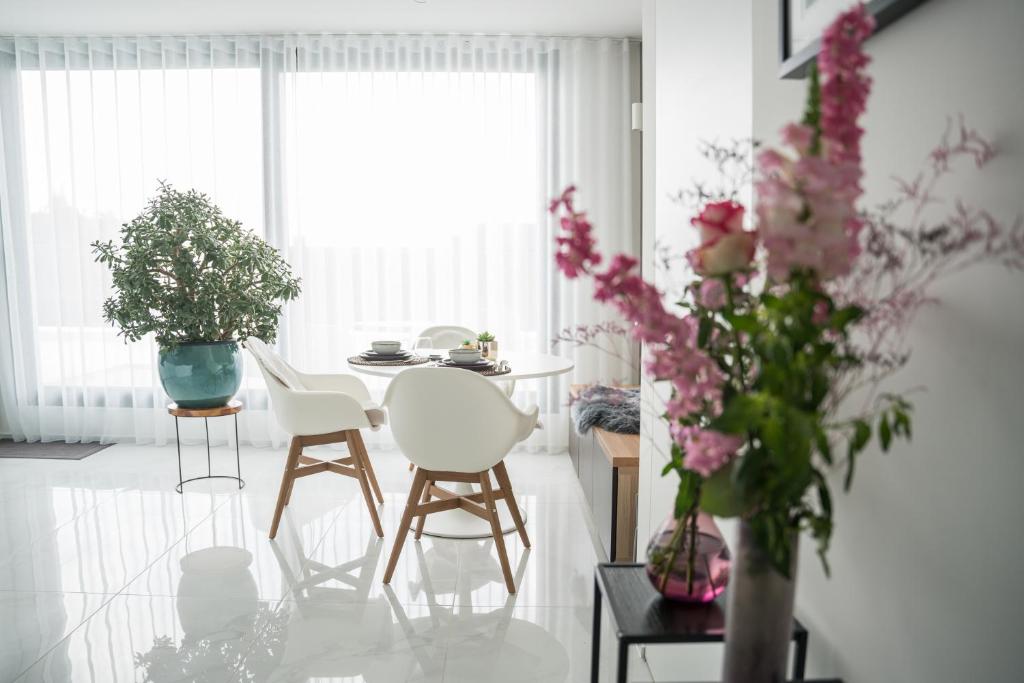 托尔豪特Blue Yvey Apartment的客厅配有椅子和鲜花桌