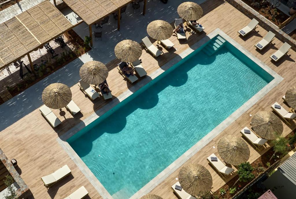 古瓦伊Volta Suites and Villas的享有带遮阳伞和椅子的游泳池的顶部景致
