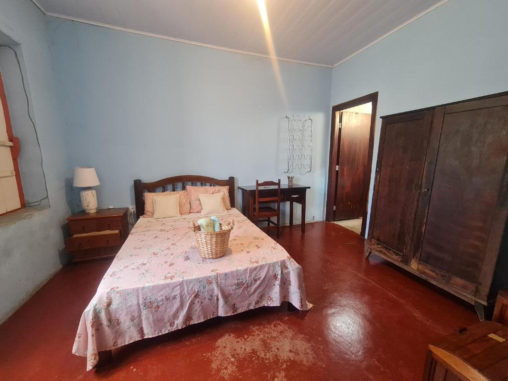 戈亚斯MAEVE Suíte Campo的一间卧室配有一张床和一张桌子