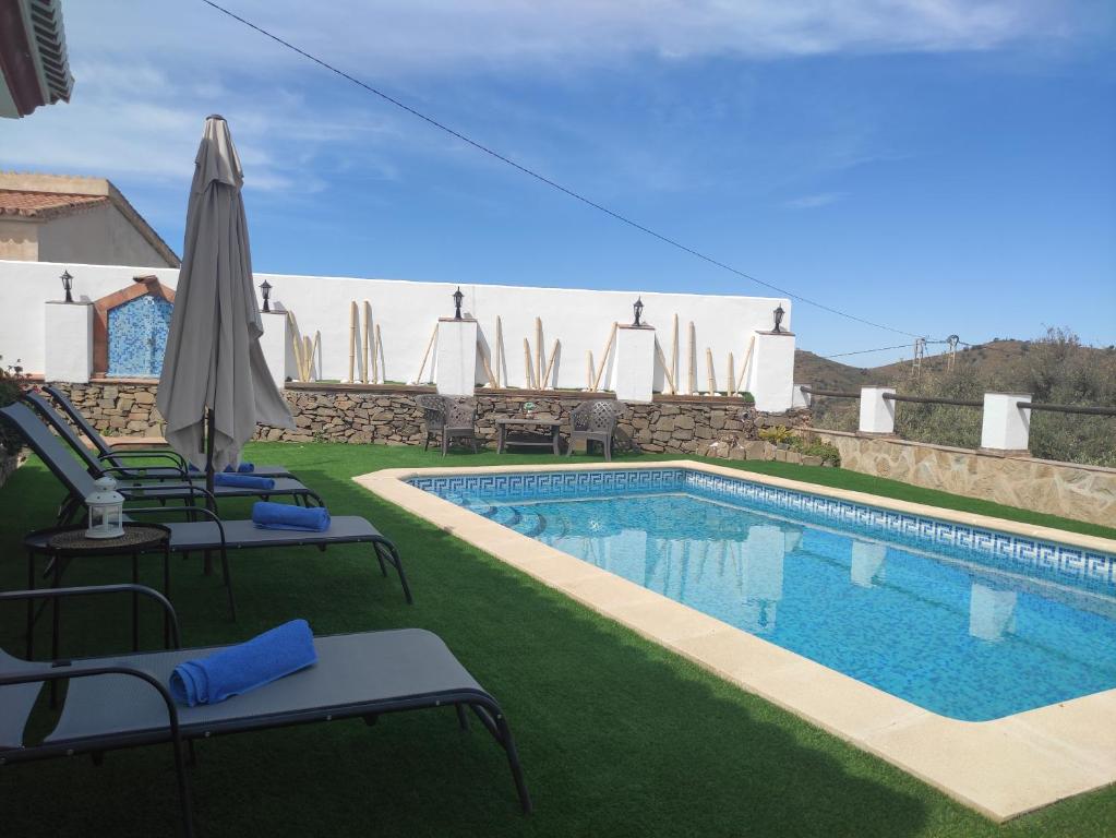 托罗克斯Casa rural Villa Miradri的一个带草坪椅和遮阳伞的游泳池