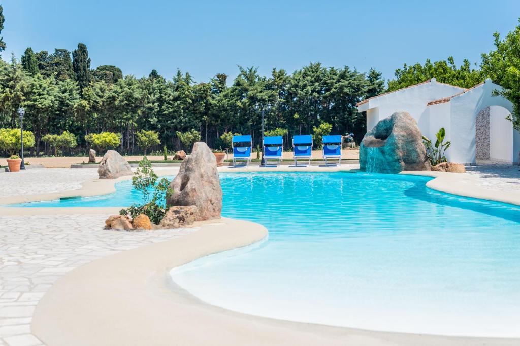 奥罗塞伊Sisula Country Hotel & SPA的度假村内带椅子和岩石的游泳池