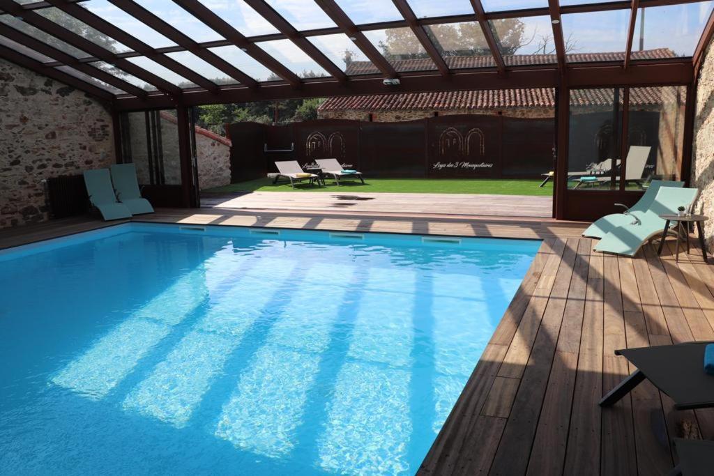 莱塞比耶Gite Porthos的一个带凉棚的大型蓝色游泳池