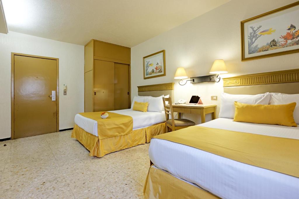 比亚埃尔莫萨Hotel Olmeca Plaza的酒店客房配有两张床和一张书桌