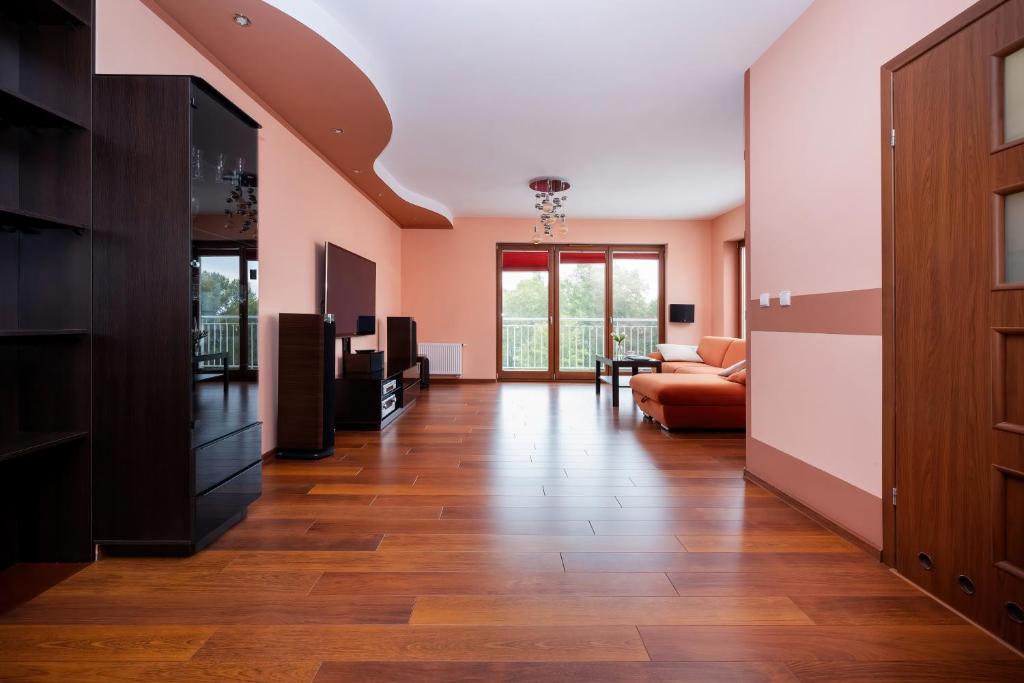 斯维诺乌伊希切Swinemünde Platan Świnoujście Platan的客厅铺有木地板,拥有粉红色的墙壁。