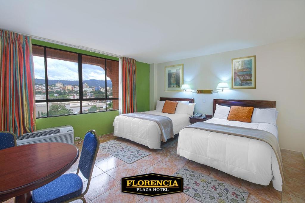 特古西加尔巴FLORENCIA PLAZA HOTEL的酒店客房设有两张床和一张桌子。