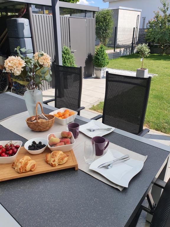 辛根Schöne Ferienwohnung Bodenseeregion的餐桌,盘子上放着食物和水果碗