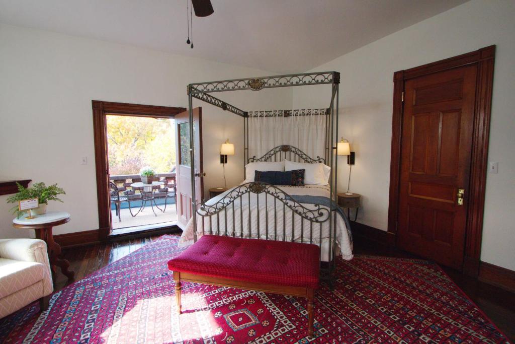 路易斯威尔Louisville Bourbon Inn的一间卧室配有一张带红色长凳的天蓬床