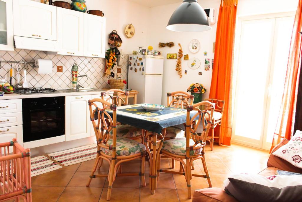 AragonaBed and breakfast Agrumi in terrazza的厨房配有桌椅和冰箱。