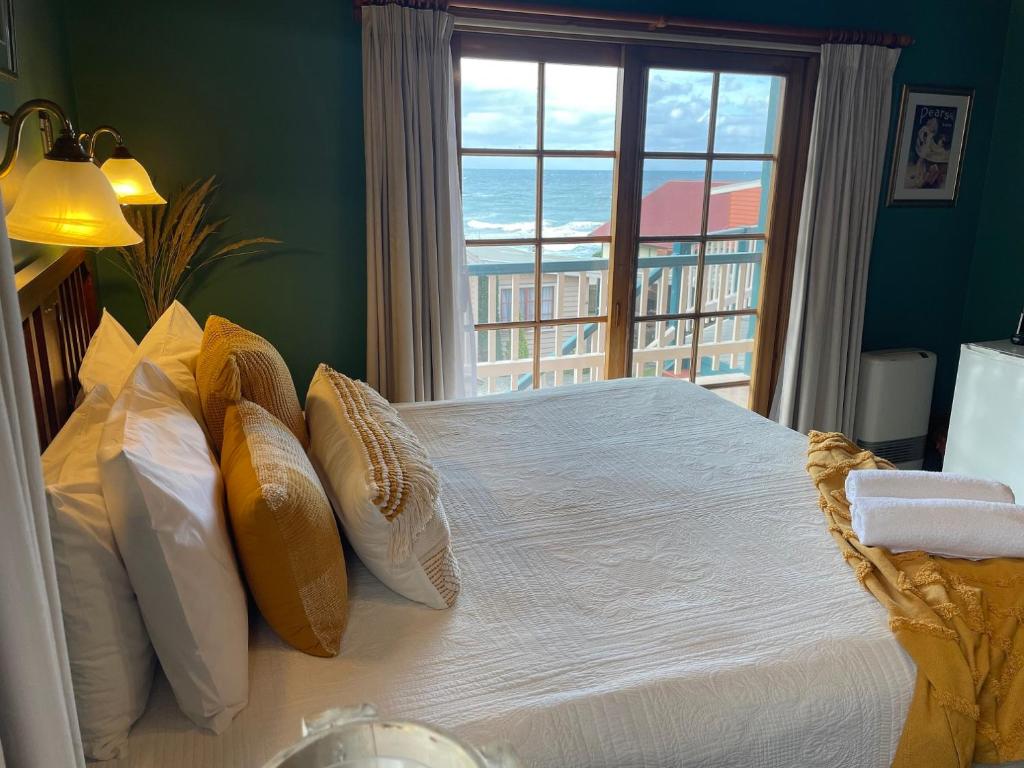 斯坦利Hanlon Guest House的一间卧室设有一张床,享有海景