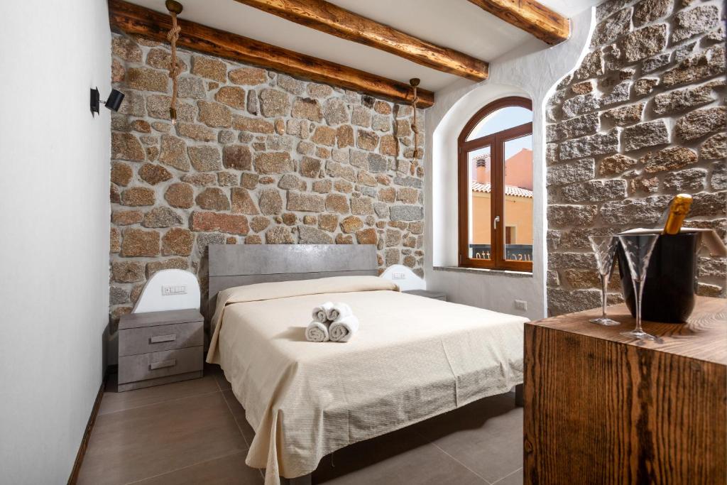 圣特雷莎加卢拉Il Busciolotto的一间卧室设有一张床和砖墙