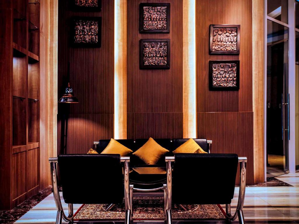 日惹Grand Mercure Yogyakarta Adi Sucipto的用餐室配有带黄色枕头的桌子