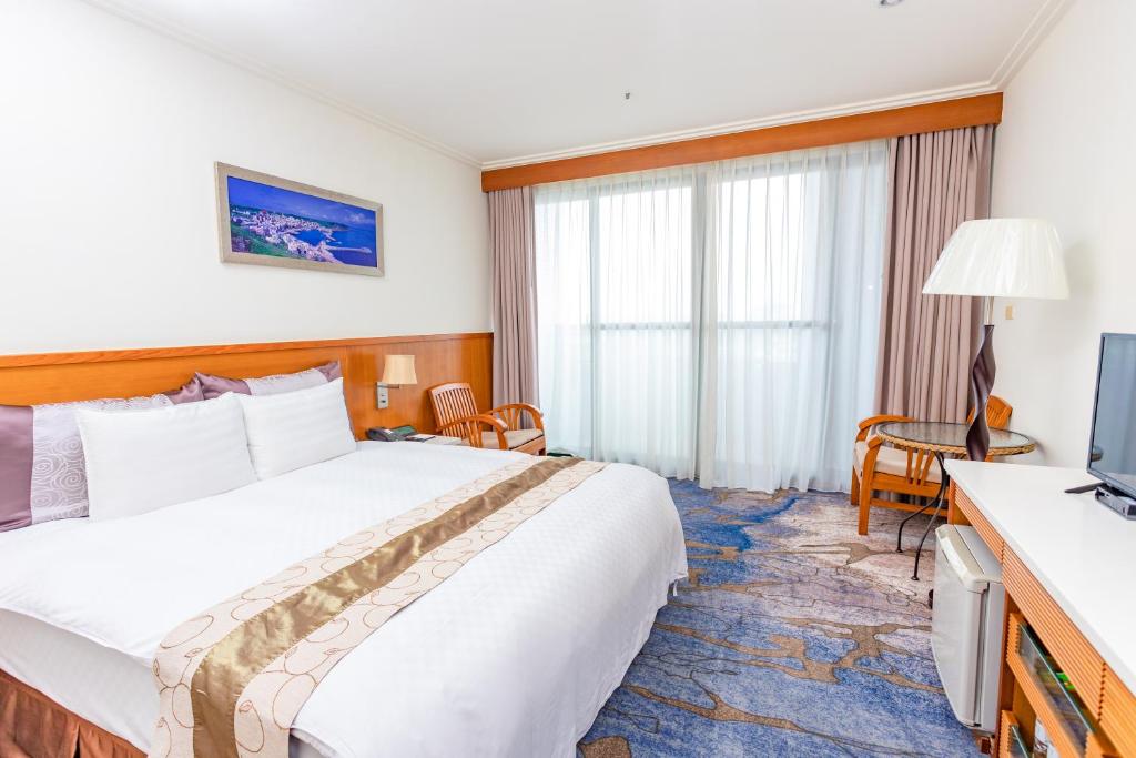 马公雅霖大饭店的酒店客房,配有床和电视