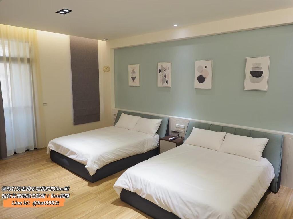 马公捌拾伍号民宿的配有白色床单的酒店客房内的两张床