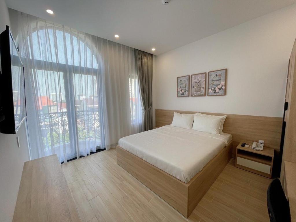 顺化Nhật Phương Hotel的一间卧室设有一张床和一个大窗户
