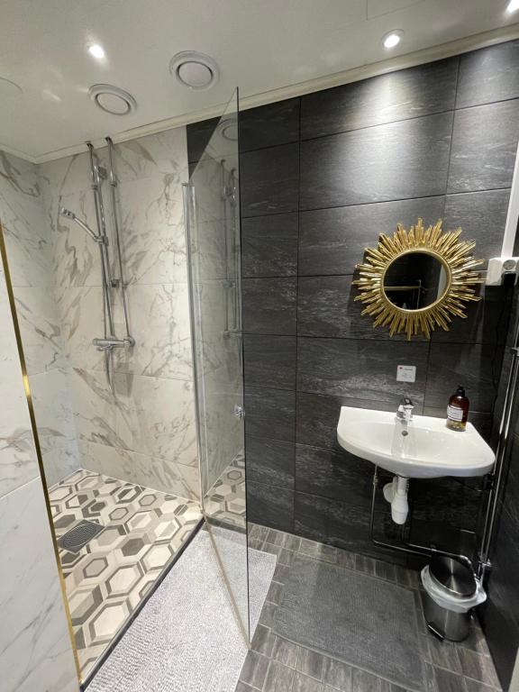 罗瓦涅米Wherever Mini Hostel的浴室配有盥洗盆和带镜子的淋浴