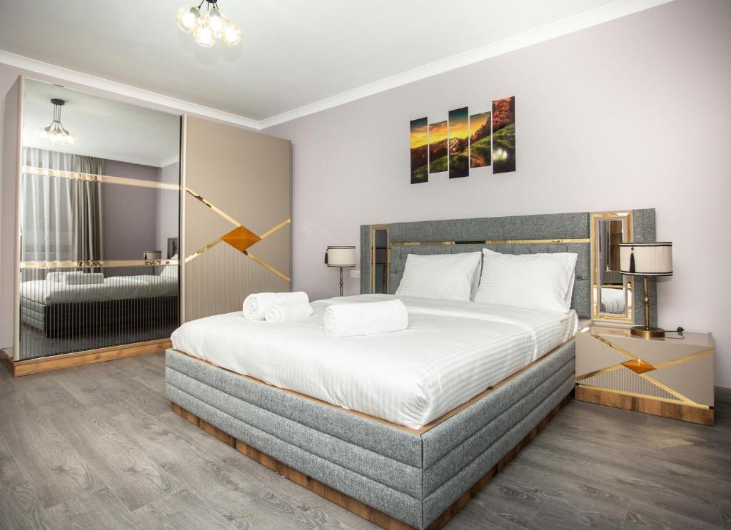 特拉布宗Gazioğlu Residence的一间卧室设有一张大床和一个大镜子
