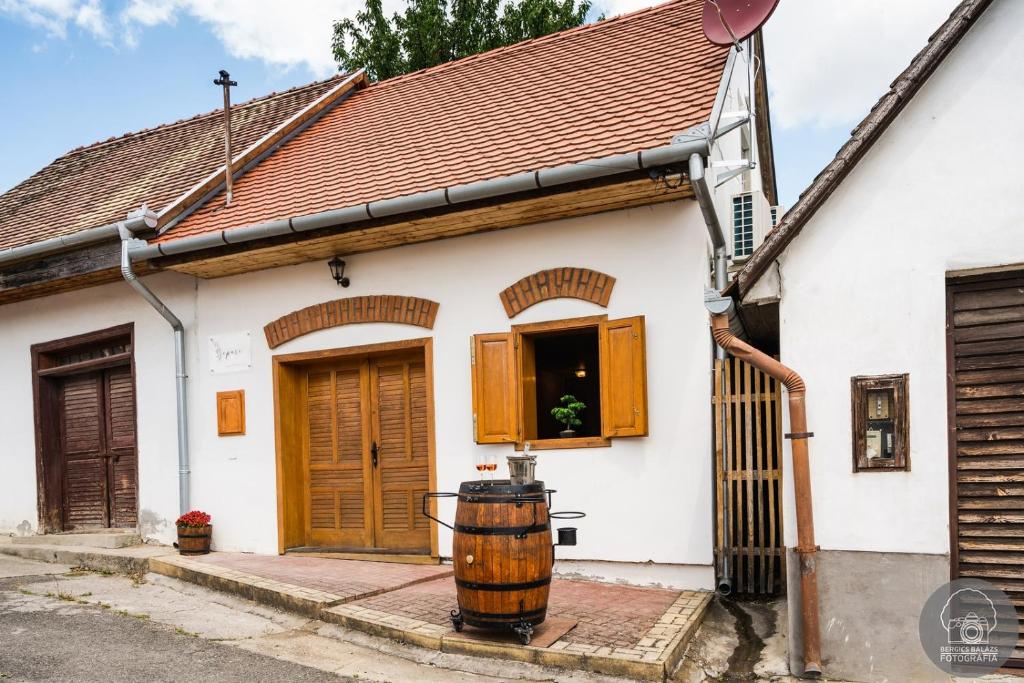 维拉尼Szeparé pinceház szállás Villány központi részén.的白色的房子,木门和桶