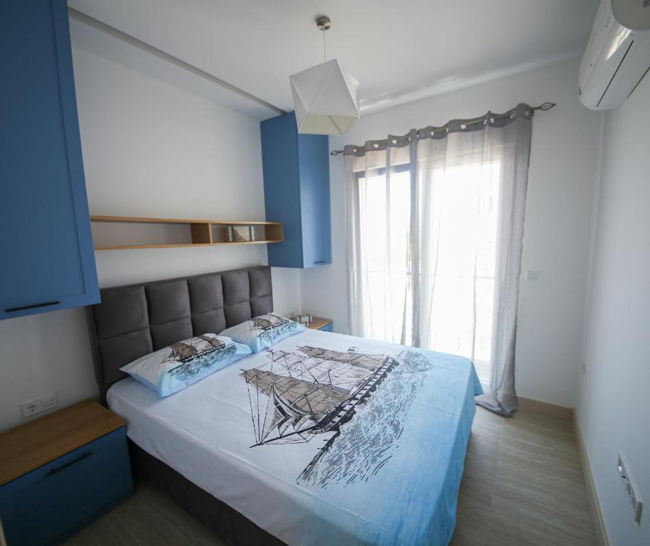 巴尔Luxury Mare apartment的一间卧室配有一张蓝色墙壁的床和一扇窗户