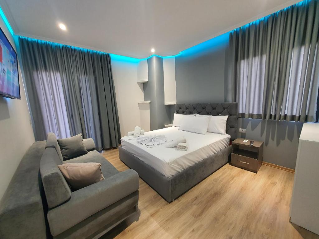 萨兰达Villa Mehmeti的一间卧室配有一张床、一张沙发和一把椅子