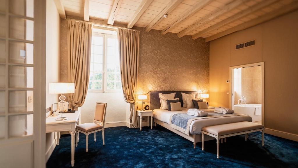 莱索里涅尔L'Abbaye De Villeneuve的一间卧室配有一张床、一张书桌和一个窗户。