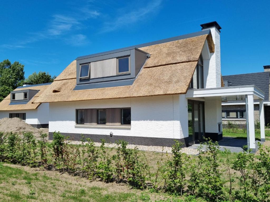 诺德韦克Duyndomein Noordwijk的白色房子,有棕色的屋顶