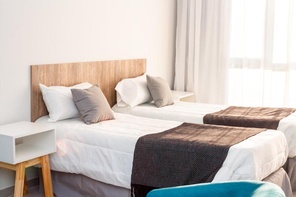 玛德琳港CQ MITRE的酒店客房,配有两张床和椅子