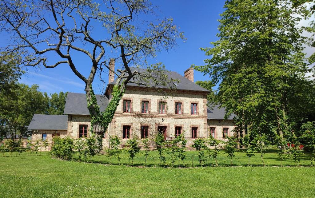 Daubeuf-ServilleManoir de Daubeuf的一座老石头房子,院子里有一棵树