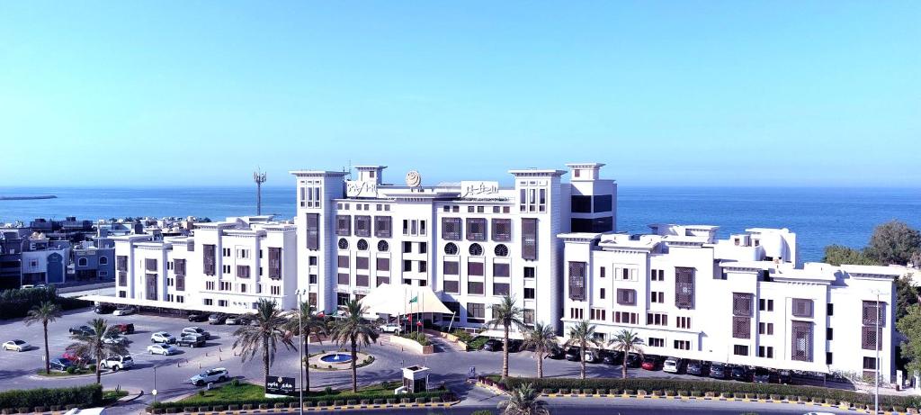 科威特科威特萨菲尔菲尼亚斯酒店的一座大白色的建筑,位于海洋前