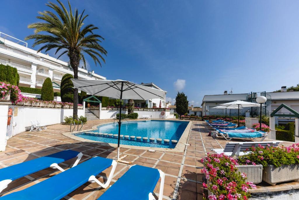 萨卡罗Bravissimo Vil·les Brusi A S'Agaró的酒店游泳池设有椅子和遮阳伞