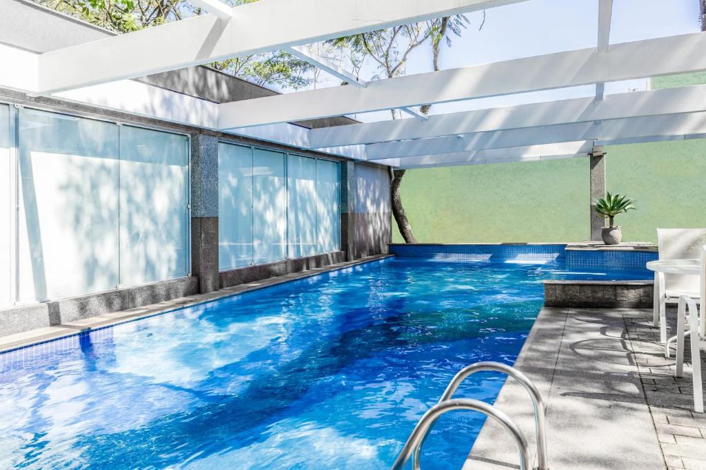 圣保罗韦博迪威诺联合国蓝树高级酒店的蓝色的游泳池和窗户
