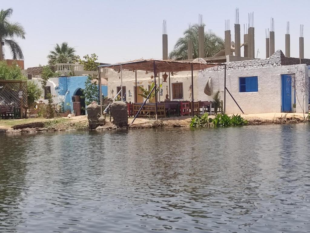 卢克索Luxor Old Nile Hotel的水体边的房子