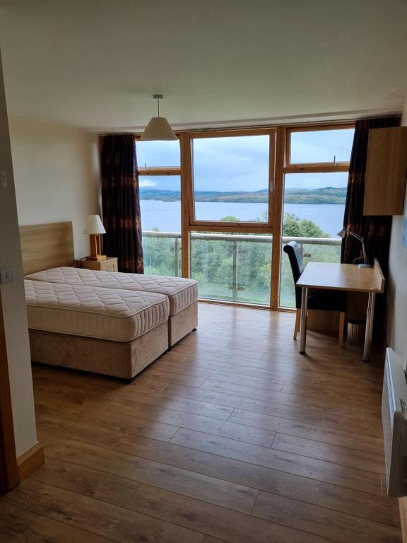 斯莱戈LILA Lake Isle Luxury Aparthotel的一间卧室配有一张床、一张桌子和一张桌子