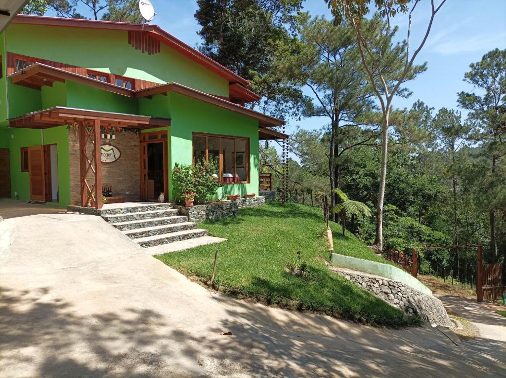 哈拉瓦科阿Mi Hogar Jarabacoa的前面有一条小路的绿色房子