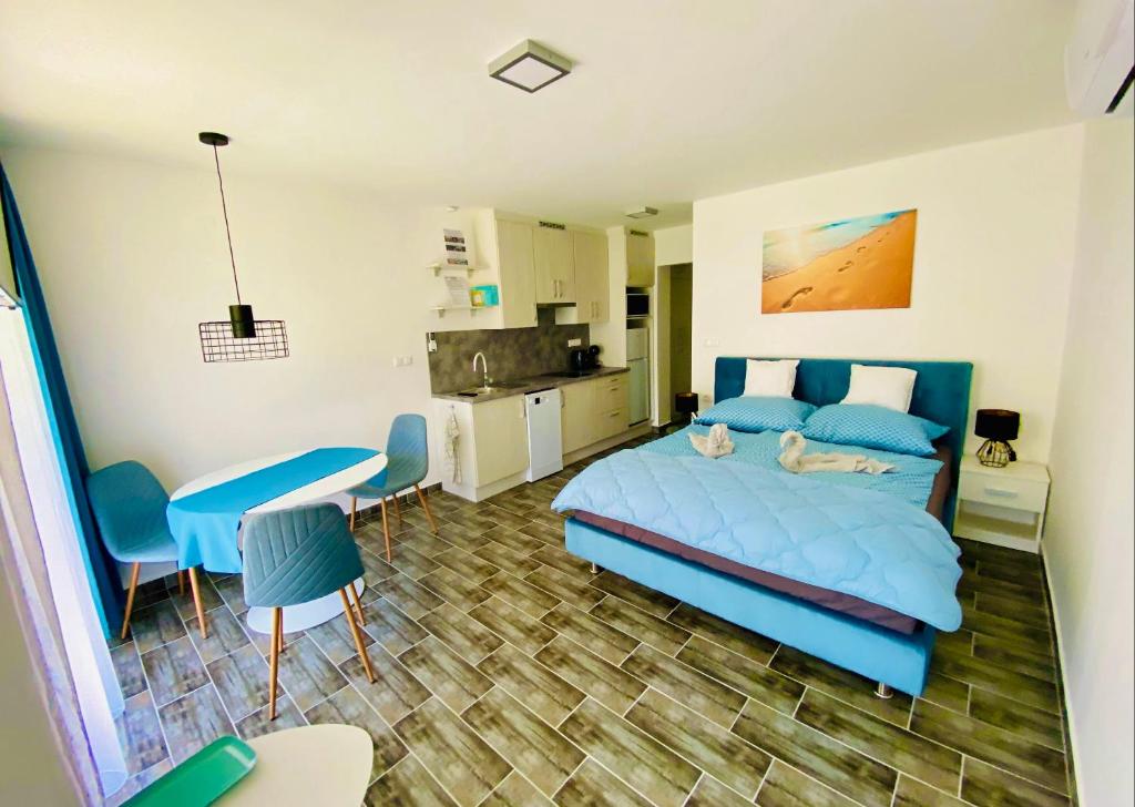 巴拉通雷勒Lilac Apartman的一间带蓝色床的卧室和一间厨房