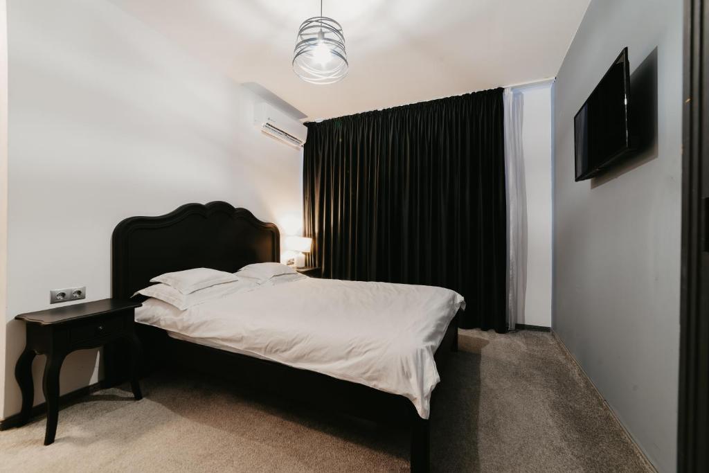 克卢日-纳波卡Meteor Central的一间卧室配有一张带黑色床头板的床