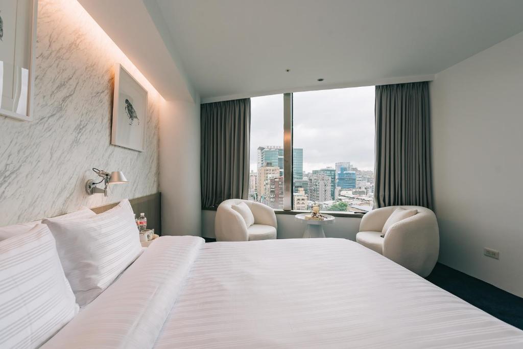 台北美寓艺术文旅 Meistay Art Gallery Hotel的酒店客房设有一张床、两把椅子和一扇窗户。