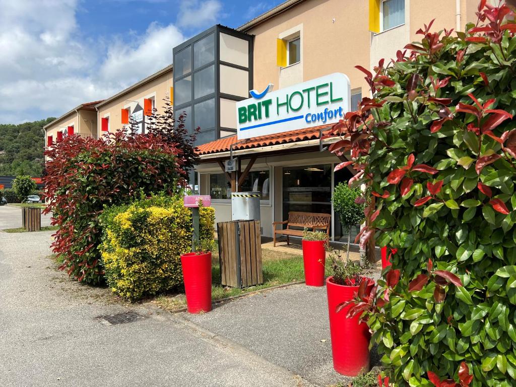 富瓦Brit Hotel Confort Foix的大楼前有红色桶的餐厅
