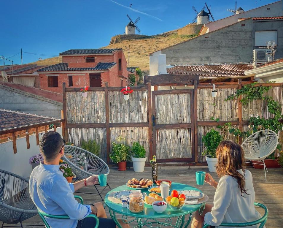 孔苏埃格拉Apartamentos Oncemolinos con desayuno的坐在餐桌旁吃饭的男人和女人